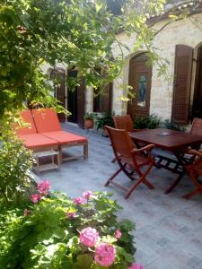 a patio with two chairs and a table and flowers at Artemisia Traditional Home in Choudetsi