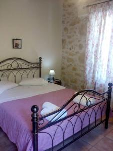 um quarto com uma cama com um cobertor rosa em Artemisia Traditional Home em Choudetsi