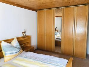 1 dormitorio con cama y espejo grande en Ferienwohnung Wieser Reizegg 7, 5652 Dienten, en Dienten am Hochkönig