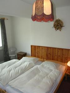 a bedroom with a white bed with a wooden headboard at Holiday Villa Herlikovice in Vrchlabí
