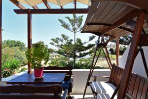 a blue table and chairs on a balcony with a tree at Batistas Apartments in Naousa