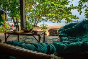 a living room with a couch and a table and a beach at Lost and Found in Koh Rong Sanloem