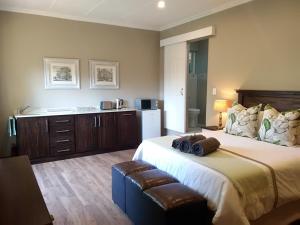 1 dormitorio con 1 cama grande y nevera en Welcome Home Cottages en Pietermaritzburg