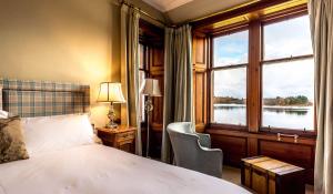 a bedroom with a bed and a large window at Shieldaig Lodge Hotel in Gairloch