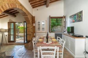 a kitchen with a table and chairs in a room at Casina di Teo by VacaVilla in Monteriggioni