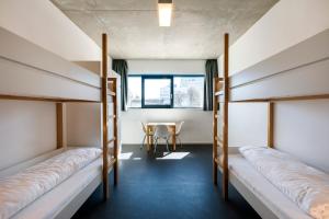 a room with three bunk beds and a table at Jugendherberge Schweinfurt in Schweinfurt