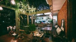 a restaurant with a table and chairs and a bar at Gajib Bed&Breakfast in Amphawa