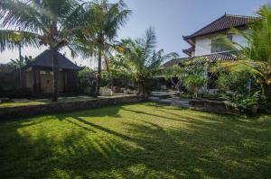 a yard in front of a house with palm trees at Villa Kami Ubud in Ubud