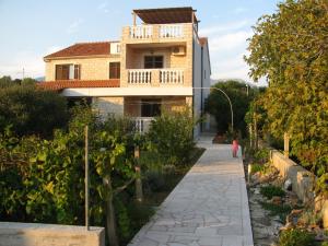 a house with a walkway in front of it at Apartments Piacun in Sućuraj