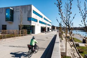 een persoon die fietst op een stoep voor een gebouw bij Jugendherberge Schweinfurt in Schweinfurt