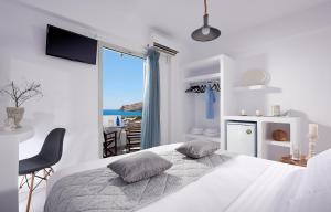 a bedroom with a bed with a view of the ocean at Muses Rooms Milos in Provatas