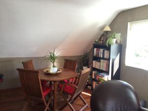 a dining room with a table with chairs and a book shelf at PETIT YATOU APPART' in Cauterets