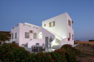 a building with a table and chairs in front of it at Muses Rooms Milos in Provatas