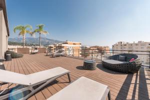 - un balcon avec des chaises et des tables dans un bâtiment dans l'établissement Résidence Pierre & Vacances Premium Julia Augusta, à Roquebrune-Cap-Martin