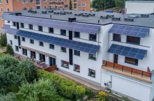 un bâtiment blanc avec des panneaux solaires sur le toit dans l'établissement Pesa Hotel, à Põlva
