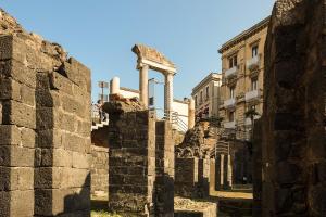 ancient ruins of a building in a city at B&B Stesicoro InHabit - GuestHouse City Center in Catania