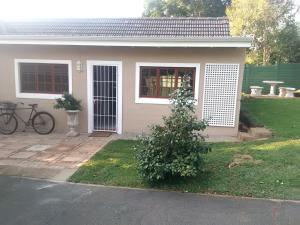 a house with a bike parked in front of it at Welcome Home Cottages in Pietermaritzburg