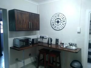 a kitchen with a counter with a clock on the wall at Welcome Home Cottages in Pietermaritzburg