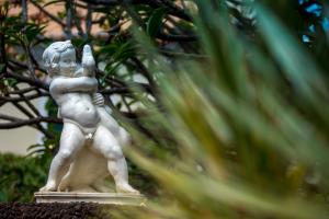 a statue of a young boy holding a cell phone at ARTS IN Hotel Conde Carvalhal in Funchal