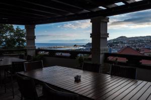 a table on a balcony with a view of the ocean at ARTS IN Hotel Conde Carvalhal in Funchal