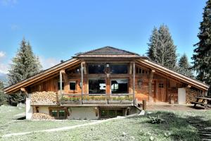 a large wooden house with a large window at Chalet Javen - 520m2 avec piscine chauffée et home cinéma in Megève