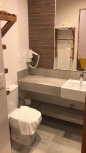 La salle de bains est pourvue de toilettes, d'un lavabo et d'un miroir. dans l'établissement Carambola Hotel, à Arraial d'Ajuda