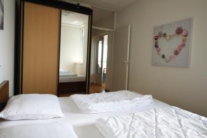 a bedroom with two white beds and a mirror at Hello Zeeland - Appartement Port Scaldis 13-111 in Breskens