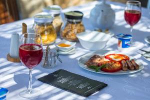 a table with a plate of food and glasses of wine at ARTS IN Hotel Conde Carvalhal in Funchal
