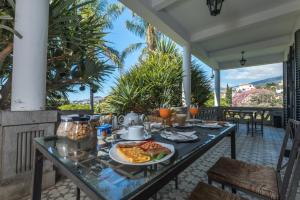 a breakfast table on a patio with food on it at ARTS IN Hotel Conde Carvalhal in Funchal