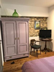 a bedroom with a cabinet and a desk with a television at Patak Apartman, Diszel in Tapolca