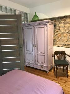 a bedroom with a bed and a cabinet and a chair at Patak Apartman, Diszel in Tapolca