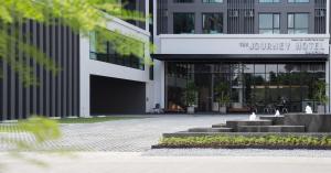 a courtyard in front of a building with a fountain at The Journey Hotel Bangna in Samut Prakan