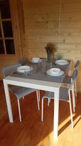 a white table with chairs and plates on it at Osada nad Szumem in Józefów