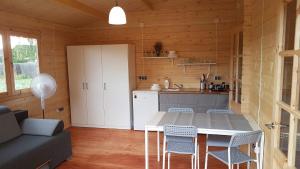 a kitchen with a table and chairs in a room at Osada nad Szumem in Józefów