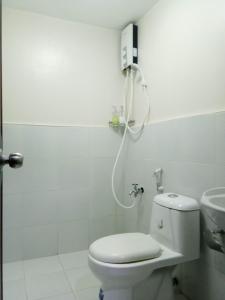 Un baño blanco con inodoro y lavabo. en Your Holiday Home( Studio, King Size Bed), en Mactan