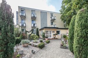 a garden in front of a building with bushes at Hotel Bären in Bad Krozingen