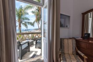 a room with a sliding glass door with a view of the ocean at ARTS IN Hotel Conde Carvalhal in Funchal
