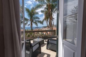 a balcony with a view of the ocean and palm trees at ARTS IN Hotel Conde Carvalhal in Funchal