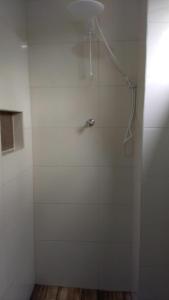 a white shower with a shower head in a bathroom at CAMINHOS DO VALE EUROPEU HOSTEL in Timbó