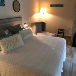 1 dormitorio con 1 cama blanca grande con silla en Cristobal Hotel Boutique en Concordia