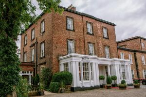 um grande edifício de tijolos vermelhos com acabamento branco em Bannatyne Hotel Darlington em Darlington