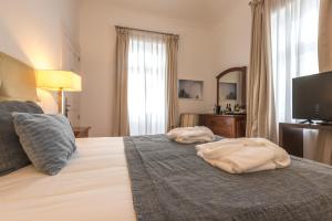 a bedroom with a bed with two towels on it at ARTS IN Hotel Conde Carvalhal in Funchal