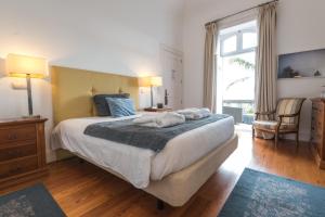 a bedroom with a large bed and a large window at ARTS IN Hotel Conde Carvalhal in Funchal