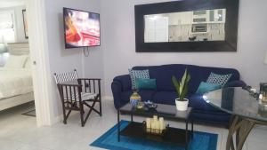 a living room with a blue couch and a glass table at Millsborough B&B in Billy Dun
