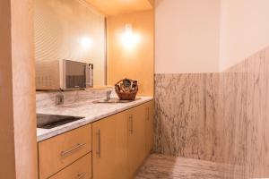 a kitchen with a sink and a microwave at ARTS IN Hotel Conde Carvalhal in Funchal