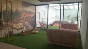 a room with a couch and chairs on a green carpet at Trevejo Hostel in Garachico