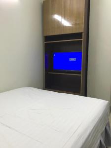 a bed in a room with a tv on a wall at Hotel Seven Star in Dhaka