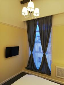 a bedroom with a window and a television at Residence Turgenev in Saint Petersburg