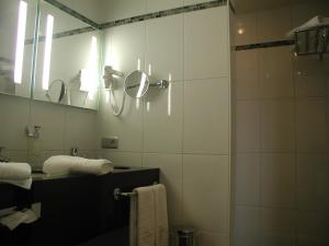 a bathroom with a shower and a mirror at Biznis Hotel in Lokeren +24 photos