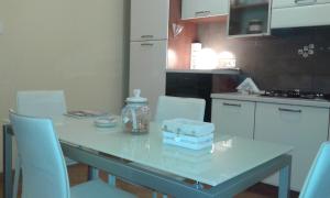 una cocina con una mesa con sillas blancas y una mesa y una mesa. en Belvedere Valenza en Terni